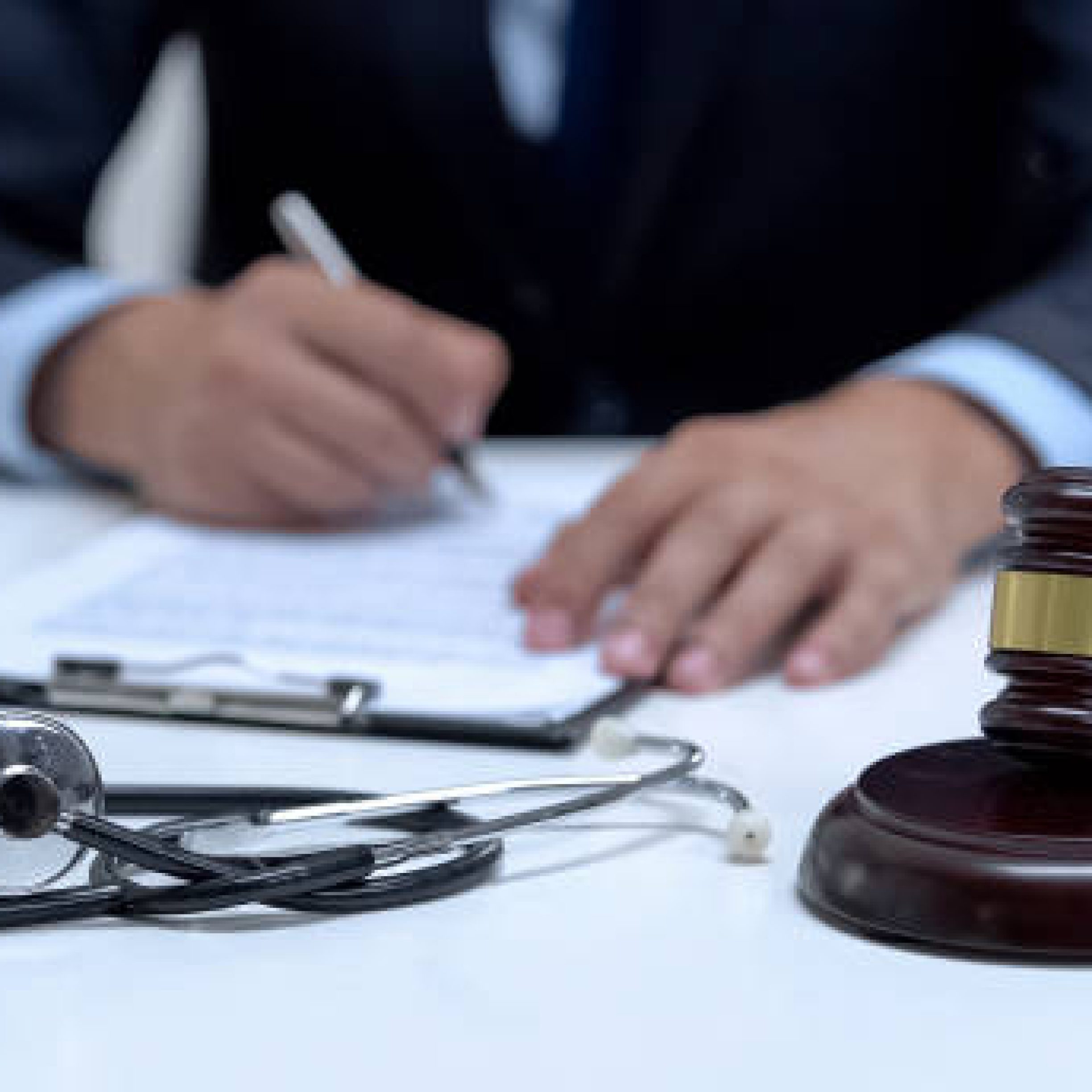 Judge signing arrest warrant for medical error, banging gavel near stethoscope